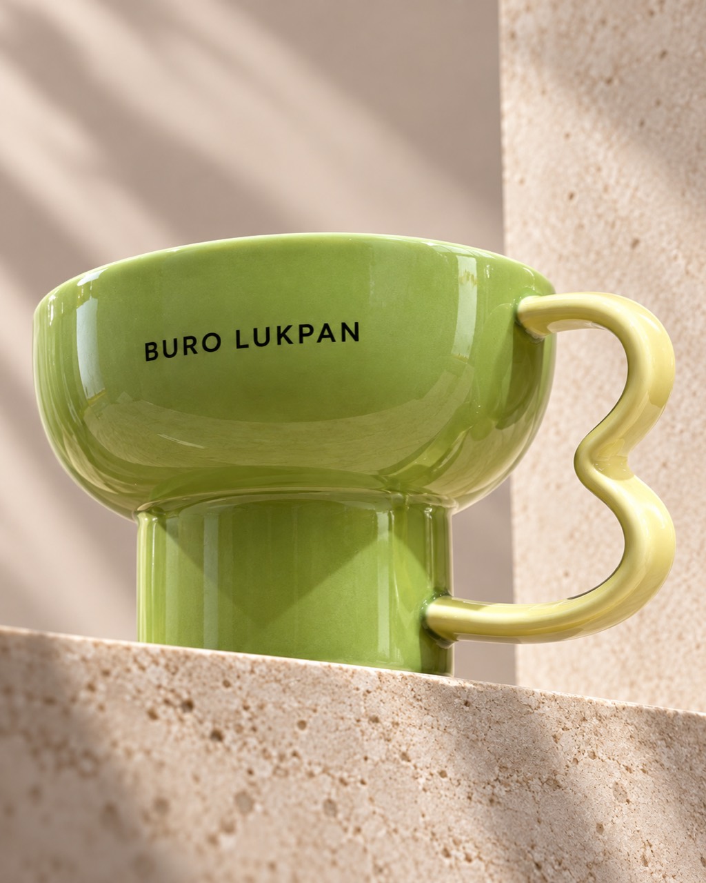 Green ceramic cup with a sculpted yellow handle: BURO LUKPAN product photograph